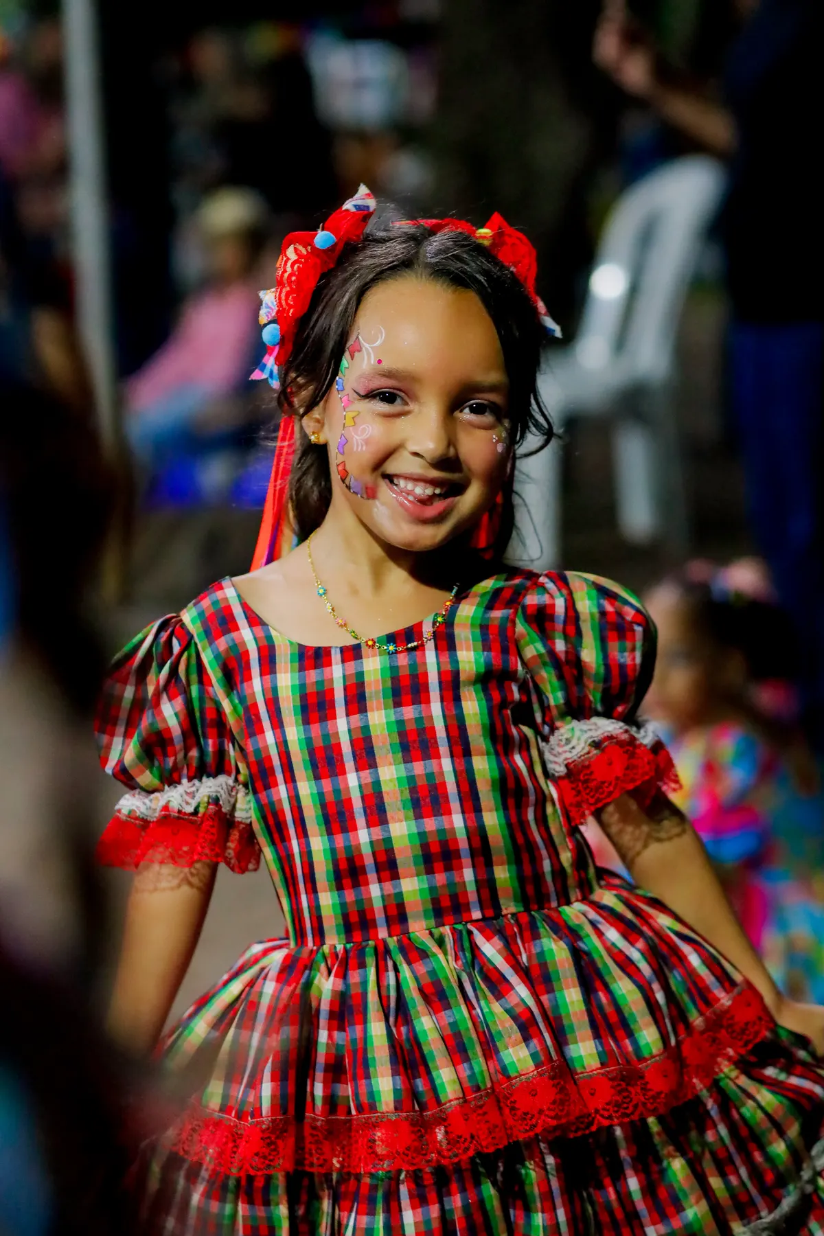 Aluna da Criarte de vestido de festa junina sorrindo na quadrilha da escola