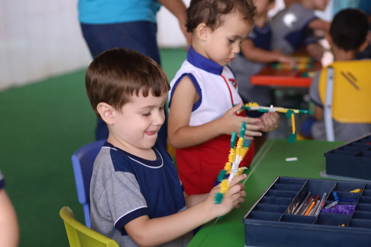 Crianças montando peças de encaixe na aula de robótica