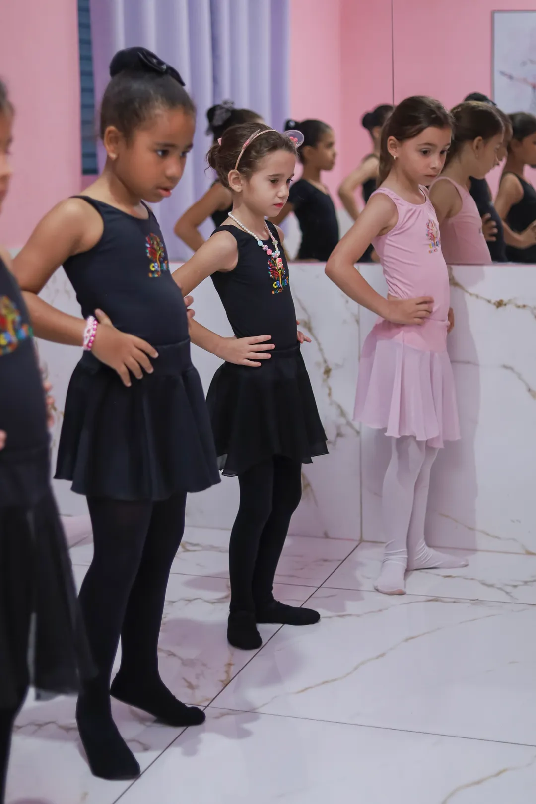 Alunas da Escola Criarte em formação durante a aula de balé, com uniforme preto